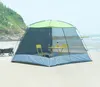 A screen house tent set up on a sandy beach with two yellow chairs and a table inside. Náhled obrázku produktu