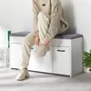 A person is sitting on a shoe bench, tying their shoe. Voir les images du produit