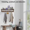 A wooden shelf with toiletries, hooks, and towels, next to a bench and umbrellas. Produktbild-Vorschau