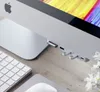 A close-up view of the side of an iMac computer with a USB-C hub attached, showing various ports and inserted SD cards. A keyboard and mouse are partially visible in the foreground. Produktbild-Vorschau