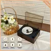 A vintage-style record player with a CD inside, next to a basket of flowers. Produktbild-Vorschau