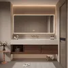A modern bathroom vanity with a large LED mirror, sink, and storage cabinets. The scene is set with a small side table and a rug on the floor. Anteprima dell’immagine prodotto