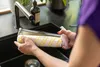 A person is cleaning a roller brush in a kitchen sink. Produktbild-Vorschau