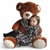 A young girl hugging a large teddy bear. Podgląd zdjęcia produktu