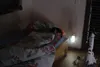 A child sleeping in bed next to a night light and a toy rocket. Produktbild-Vorschau