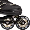 A close-up view of the wheels and frame of a black and beige inline skate. Náhled obrázku produktu
