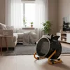 A ceramic electric heater is placed on a rug in a living room setting. Voir les images du produit