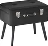 A black velvet ottoman designed to look like a vintage suitcase, with four dark wooden legs. Náhled obrázku produktu