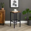 A bar stool is placed in a room with a cabinet and a plant. Podgląd zdjęcia produktu