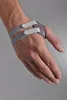 A close-up shot of a person's hand wearing a thumb orthosis. Anteprima dell’immagine prodotto