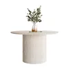A round dining table with a fluted base, topped with a vase of greenery. Produktbild-Vorschau