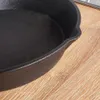 A close-up view of a black cast iron skillet on a wooden surface. Náhled obrázku produktu