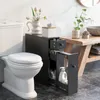A bathroom scene featuring a toilet, a narrow black cabinet next to it, and a wooden vanity with a sink in the background. Náhled obrázku produktu