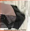 Close-up of a shopping roller with a beige fabric and black mesh details, resting against a wooden wall. Voir les images du produit