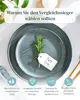 A close-up overhead view of two plates with a sprig of rosemary and a tag on them, with marketing text and icons at the bottom. Produktbild-Vorschau