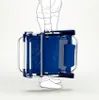 A person is holding a folded blue beach chair. Voir les images du produit