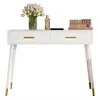A white vanity table with gold accents, featuring two drawers and decorative elements on top. Podgląd zdjęcia produktu