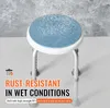 A shower stool with water droplets falling on it, set against a textured gray background. Produktbild-Vorschau