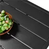 A close-up view of a black metal table with a bowl of green grapes. Produktbild-Vorschau
