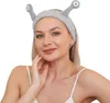 A woman wearing a gray cosmetic headband with alien-like antennae. Produktbild-Vorschau