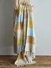 A person holding a colorful striped blanket. Produktbild-Vorschau