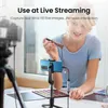 A woman is live streaming and demonstrating makeup application using a smartphone mounted on a tripod, with a video capture device connected. Náhled obrázku produktu