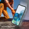 A person in work clothes is kneeling on rough terrain, with a smartphone in a protective case prominently displayed in the foreground. Produktbild-Vorschau