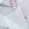 A close-up view of a white sheer curtain with a floral pattern. Produktbild-Vorschau