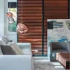 A modern living room with a white sofa, gray armchair, wooden blinds, and a large abstract painting. Produktbild-Vorschau