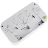 The back of a white digital alarm clock is shown, with battery compartment and buttons visible. Náhled obrázku produktu