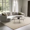 A modern living room with a large sectional sofa, coffee table, and rug. Produktbild-Vorschau
