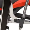 A close-up view of a metal hinge mechanism on a piece of exercise equipment, with red padding visible in the background. Produktbild-Vorschau