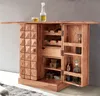A wooden bar cabinet with a bottle of liquor and a glass on top, set against a concrete wall and a rug. Produktbild-Vorschau