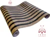 A roll of wallpaper with a wood grain and black stripe pattern, shown diagonally on a white background. Anteprima dell’immagine prodotto