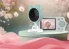 A baby monitor set with a camera and a parent unit, displayed on a decorative stand with a floral background. Náhľad obrázku produktu