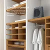 A compact heater is placed on a shelf in a closet, next to hanging clothes. The image also shows shelves with folded towels. Voir les images du produit