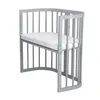 A gray crib with a white mattress on a white background. Produktbild-Vorschau