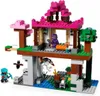 A LEGO Minecraft training ground playset with a multi-level building and surrounding environment. Produktbild-Vorschau