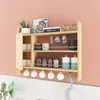 A wooden kitchen shelf mounted on a light pink wall, displaying various kitchen items. Podgląd zdjęcia produktu
