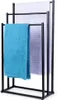 A black metal towel rack with three bars, holding three different colored towels. Anteprima dell’immagine prodotto