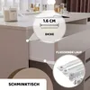 A close-up view of a white vanity table with a drawer partially open, showcasing its features and construction. Voir les images du produit