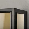 A close-up view of the corner of a black outdoor wall light with a gold-colored glass panel. Produktbild-Vorschau