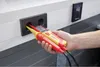 A hand is holding a voltage tester and inserting its probes into an electrical outlet. Náhľad obrázku produktu