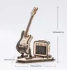 A wooden model of an electric guitar and amplifier on a display stand, with dimensions indicated by measurement lines and text. Voir les images du produit
