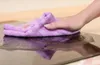 A hand is wiping a wet surface with a purple microfiber cloth. Anteprima dell’immagine prodotto
