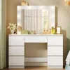 A white vanity table with a lighted mirror and various makeup items on top, set in a bedroom. Produktbild-Vorschau