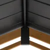 A close-up view of the corner joint of a wooden structure, likely a carport or pavilion, showing the connection between wooden beams and a dark-colored roof structure with black metal brackets. Náhled obrázku produktu