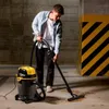 A man is vacuuming a concrete floor in what appears to be a garage or industrial setting. Anteprima dell’immagine prodotto