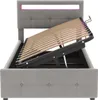 A grey upholstered bed frame with the mattress support slats lifted to reveal storage space underneath. The headboard has integrated LED lighting. Produktbild-Vorschau