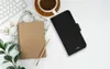 A flat lay of a black PURO wallet case for an iPhone 13 Pro, placed next to a notebook, pen, coffee cup, and keyboard. Náhled obrázku produktu